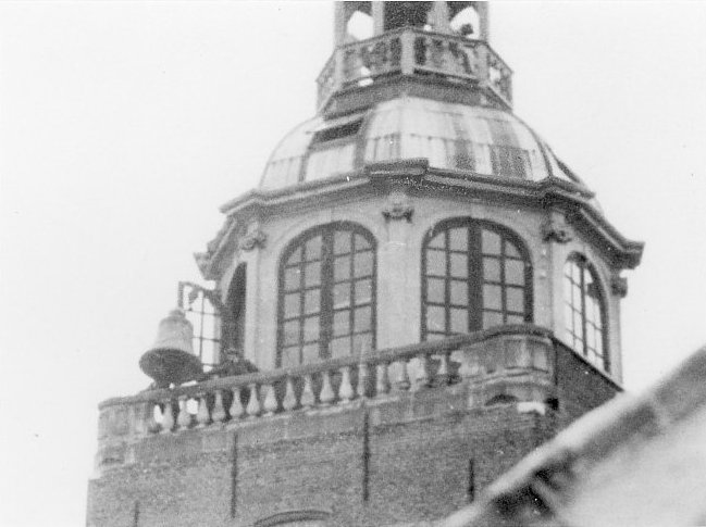 De klok uit het stadhuis bungelt buiten de toren, voor deze afdaalt naar de grond om weggevoerd te worden.