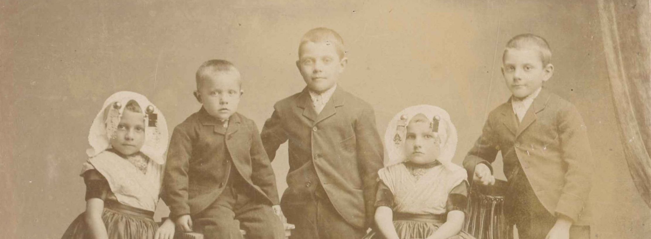 Portret van vijf kinderen, twee meisjes in Zuid-Bevelandse dracht en drie jongens.