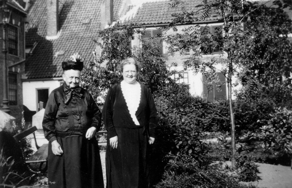 twee oudere mensen poseren voor foto in tuin van het manhuis
